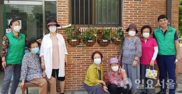 범물1동의 한 경로당 어르신들이 포켓정원 앞에서 기념촬영하고 있다.