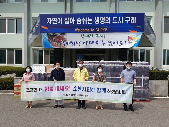 전남 순천시 왕조2동 행사추진위가 구례군 이재민에게 생활용품을 전달하고 기념사진을 촬영하고 있다.