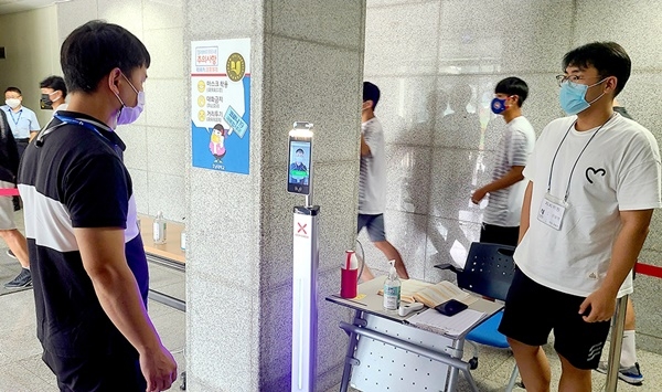 ▲호남대 기숙사에 거주하는 학생들이 건물 입구에 설치된 비대면 안면인식 발열감지 카메라 앞에서 발열검사를 하고 있다.(사진제공=호남대학교)