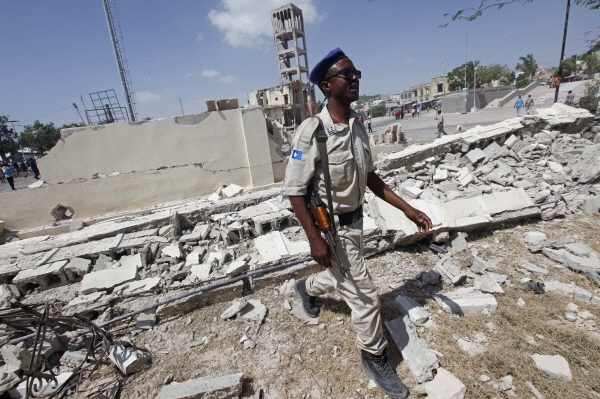 소말리아 무장 경찰이 22일 (현지시간) 대통령 궁 인근 군 검문소에서 발생한 테러 현장을 지나고 있다. 이날 발생한 테러로 최소 16명이 사망하고 20명이 부상을 입었다. [뉴시스]