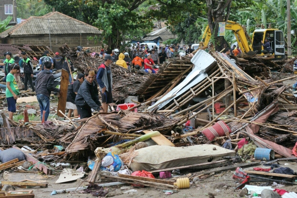 인도네시아 카리타에서 23일 주민들이 하루 전 발생한 쓰나미로 파괴된 주택을 살펴보고 있다. [뉴시스]