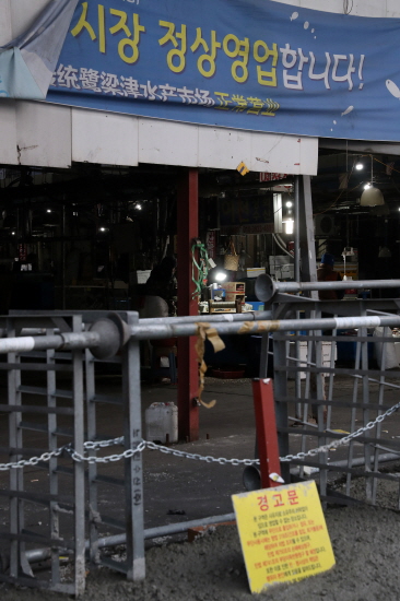 지난 8일 오후 서울 동작구 노량진 수산시장 입구가 콘크리트 작업으로 폐쇄돼 있다. 이날 아침 수협 관계자들은 구시장 내 차량 진·출입을 통제하기 위해 남은 입구를 대형차와 콘크리트로 폐쇄했다. [뉴시스]
