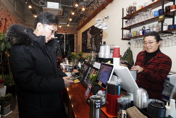 지난 25일 이창우 동작구청장이 상도동 소재 한 커피전문점을 찾아 휴대폰을 이용, 제로페이로 결제하고 있다.