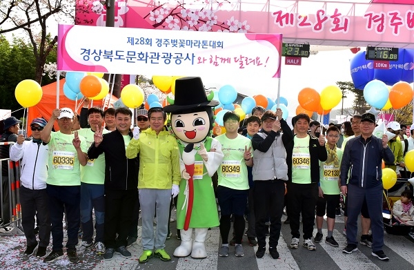김성조 경북문화관광공사 사장과 임직원들이 벚꽃마라톤 대회장에서 선비투어 캐릭터와 함께 단체기념사진을 찍고 있다.