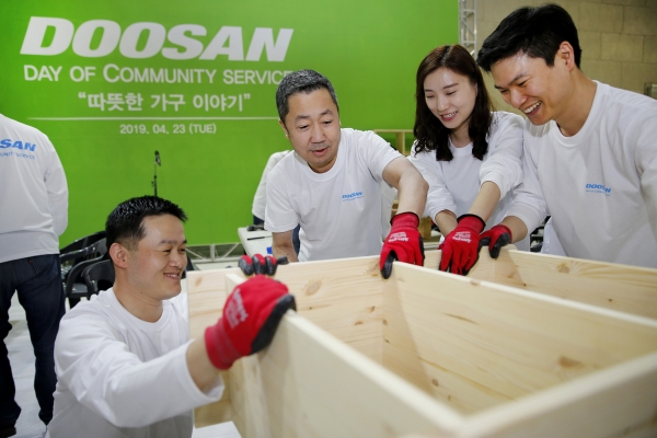 박정원 두산그룹 회장(가운데)이 임직원들과 함께 인근 지역 가정에 전달할 가구를 제작하고 있다. (사진-두산그룹)