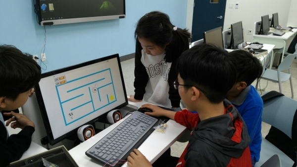 마포중앙도서관의 특기적성프로그램 중 블록 코딩으로 프로그램 언어를 배우고 있는 어린이들