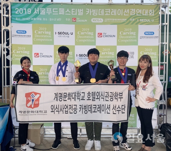 ‘2019 서울 푸드 페스티벌 카빙데코레이션 경연대회’에서 수상한 학생들이 메달과 트로피를 보이며 활짝 웃고 있다. 사진=계명문화대학교