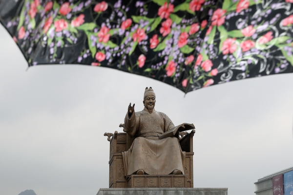 봄비가 내리는 30일 오후 서울 종로구 광화문 광장에서 한 시민이 쓴 우산 뒤로 세종대왕 동상이 보이고 있다. 2019.03.30. [뉴시스]