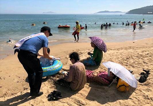 완도해양경찰서 관계자가 신지면 명사십리 해수욕장에서 구명조끼 입기 캠페인을 펼치고 있다