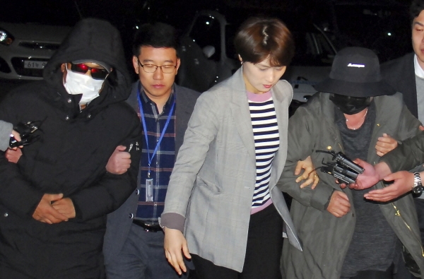 지난 4월 8일 인천공항에서 체포된 래퍼 마이크로닷(본명 신재호·25)의 부모 신모(61)씨 부부가 충북 제천경찰서로 압송되고 있다. [뉴시스]