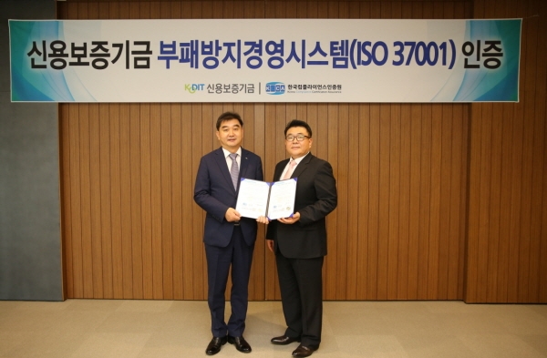 채원규 신용보증기금 전무이사(왼쪽)가 한국컴플라이언스인증원 이원기 원장(오른쪽)과 함께 25일 대구 신용보증기금 본점에서 개최된 부패방지경영시스템(ISO 37001) 인증식에서 기념촬영을 하고 있다.