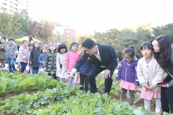 30일 도시농업공원 준공식에 참여한 박준희 구청장이 아이들과 텃밭 경작물을 구경하고 있다