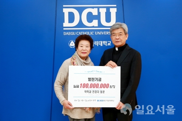 전경자 동문(왼쪽)이 김정우 총장에게 발전기금을 전달하고 있다. 사진제공=대구가톨릭대