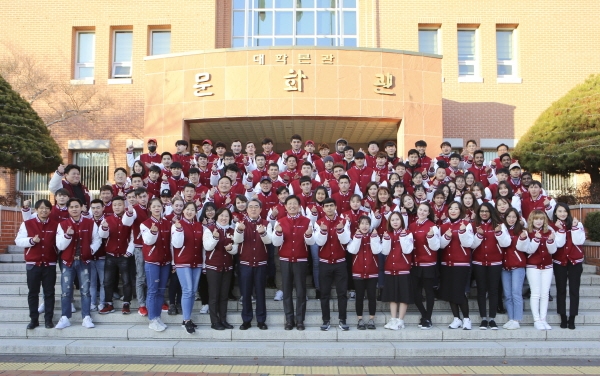 선물 받은 겨울점퍼를 입은 유학생들과 박승호 총장을 비롯한 대학관계자들이하트를 보이며 즐거워하고 있다.