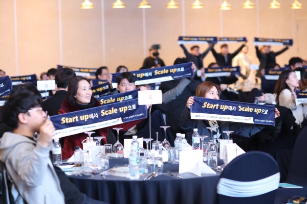 대구경북 소셜벤처 연말대잔치 참석자들이 창업 팀을 응원하는 문구가 적힌 수건을 들고 단체 세레머니를 하고 있다.