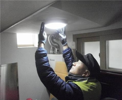 ▲ 동대문구 빗물펌프장에 근무하는 직원이 봉사활동으로 복지시설의 노후 램프를 교체하고 있다