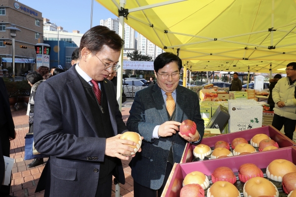 유두석 장성군수와 김삼호 광산구청장이 로컬푸드 직거래 장터에서 판매 중인 지역 농산물을 구경하고 있다.