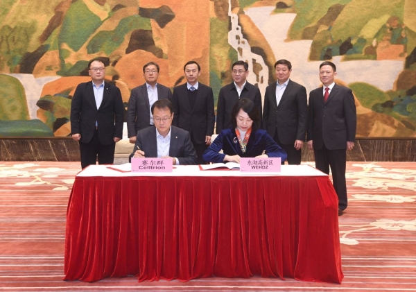 기우성(앞줄 왼쪽) 셀트리온 대표이사 부회장과 천핑(Chen Ping) 동호개발구 당공위 부서기가 20일 중국 우한에서 열린 '바이오의약품 생산공장 설립을 위한 업무협약식'에서 협약서에 서명을 하고 있다. [셀트리온 제공]