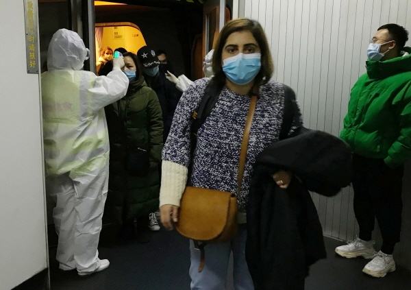 보호복을 입은 방역 관계자들이 22일 베이징 공항에서 우한시로부터 도착한 승객들의 체온을 체크하고 있다. 중국은 23일 0시(한국시간 오전 1시) 우한 폐렴 확진 환자 수가 총 547명이며 이중 17명이 숨졌다고 밝혔다. 또 31개 중국 행정구 가운데 23개에서 환자가 발생해 중국의 3분의 2 이상으로 우한 폐렴이 확산됐다고 말했다. [뉴시스]