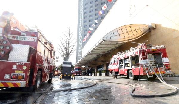 26일 오전 지하에서 원인을 알 수 없는 화재가 발생한 서울 중구 장충동 그랜드 앰배서더 호텔 앞에 소방차들이 서 있다. 화재는 오전 4시51분경 발생해 오전 10시경에 상황이 종료됐다. 화재 연기를 들이마신 투숙객과 호텔직원등 37명이 병원으로 옮겨졌고 600여 명이 대피했다. [뉴시스]