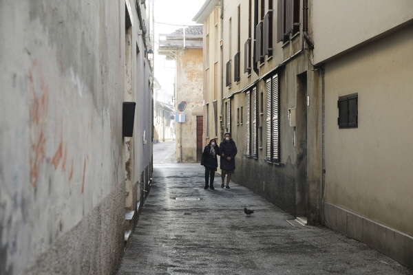 신종 코로나 바이러스 감염증 사망자가 발생해 봉쇄된 이탈리아 코도뇨에서 지난 22일(현지시간) 두 여성이 마스크를 쓴 채 텅빈 골목길을 걸어가고 있다. [뉴시스]
