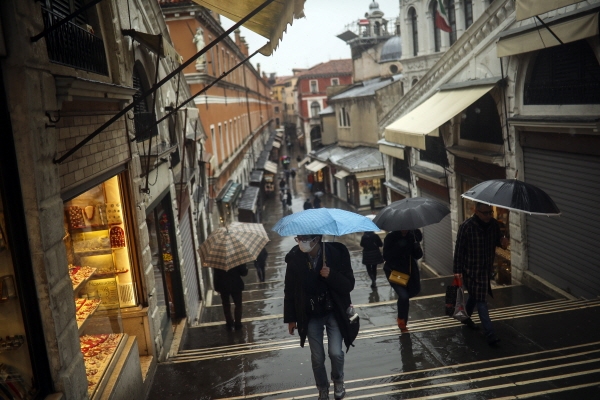 1일(현지시간) 이탈리아 북부 베테토주에 비가 오는 가운데 리알토 다리에서 시민들이 마스크를 착용하고 우산을 쓴 채 걷고 있다. 이 지역에서는 신종 코로나바이러스 감염증(코로나19) 확진자가 다수 나왔다. [뉴시스]