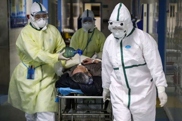 중국 후베이성 우한의 한 병원에서 6일 보호복을 입은 의료진이 코로나 19 환자를 격리병동으로 옮기고 있다. 2020.02.13. [뉴시스]