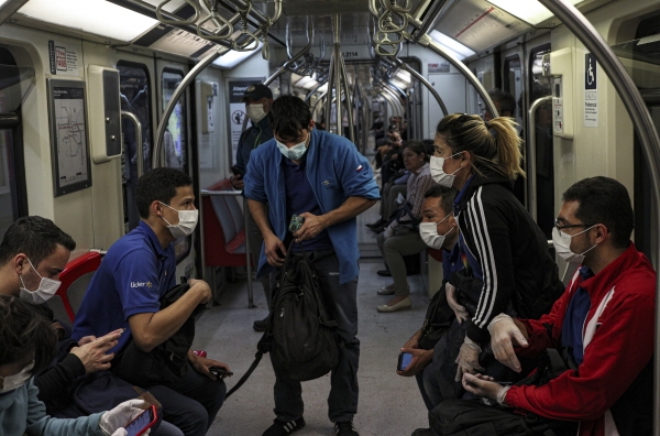 칠레의 수퍼마켓 직원들이 18일(현지시간) 수도 산티아고의 지하철 안에서 모두 마스크를 착용한채 이야기를 나누고 있다. [뉴시스]