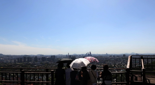비가 그친 후 맑은 날씨를 보인 지난 28일 오후 서울 용산구 남산에서 양산을 시민들이 파란하늘을 바라보고 있다. [뉴시스]