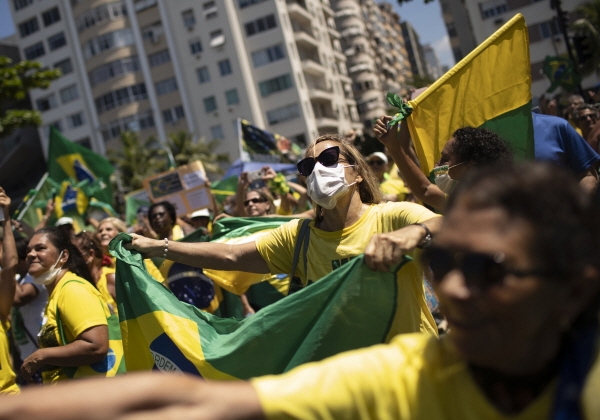 지난 15일(현지시간) 브라질 리우데자네이루의 코파카바나 해변에서 자이르 보우소나루 대통령 지지 시위가 열려 마스크를 쓴 한 여성이 브라질 국기를 들고 시위에 참여하고 있다. [뉴시스]