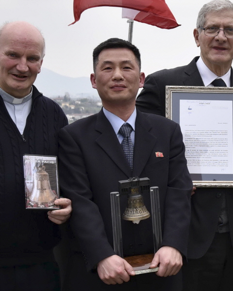 지난해 3월 20일 조성길(가운데) 이탈리아주재 북한 대사대리가 이탈리아 산피에트로디펠레토에서 열린 문화 행사에서 '로베레토 자유의 종'을 들고 있는 모습. [뉴시스]