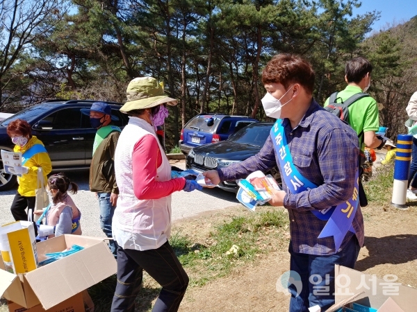 지난 5일, 종남산 일대에서 상남면 사회단체 회원이 방문객에게 코로나19예방 물품을 나눠주고 있다. @ 밀양시 제공