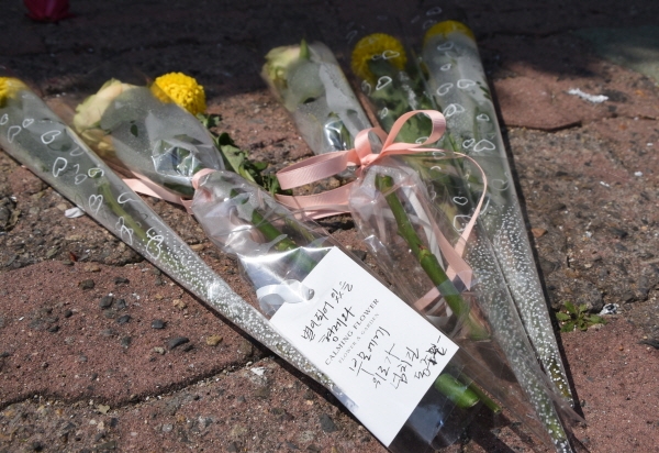 지난 9일 오후 화재가 난 울산시 동구 전하동 한 아파트 앞에 울산형제들을 추모하기 위한 꽃들이 놓여있다. [뉴시스]