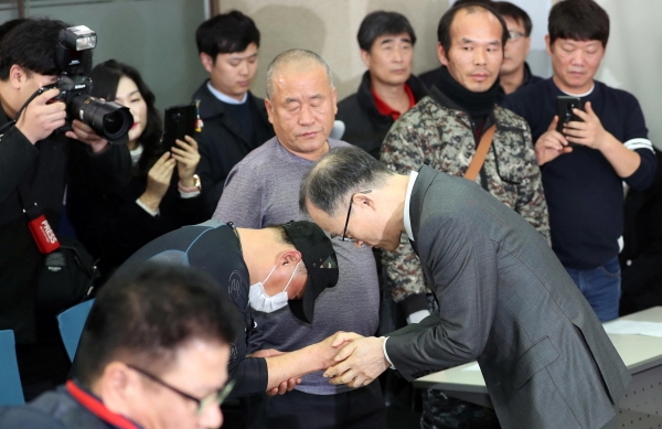 문무일(오른쪽) 전 검찰총장이 지난 2018년 11월27일 오후 서울 영등포구 여의도 이룸센터에서 '부산 형제복지원사건' 과 관련해 피해자들의 손을 잡으며 사과하고 있다. [뉴시스]