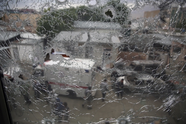 지난 12일 무장괴한들의 공격을 받은 아프가니스탄 수도 카불의 한 산부인과 병원의 부서진 창문 밖으로 군인들의 모습이 보이고 있다. [뉴시스]
