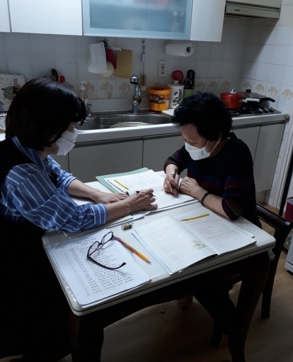 수성이도학당 강사가 어르신 집을 방문해 한글수업을 하고 있다.