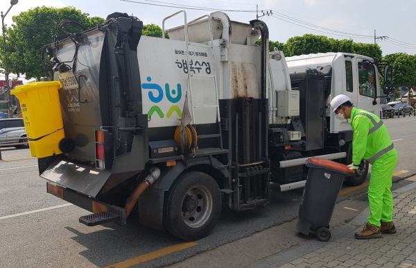 대구 수성구청 환경미화원이 수거 차량에 음식물쓰레기를 옮기고 있다.