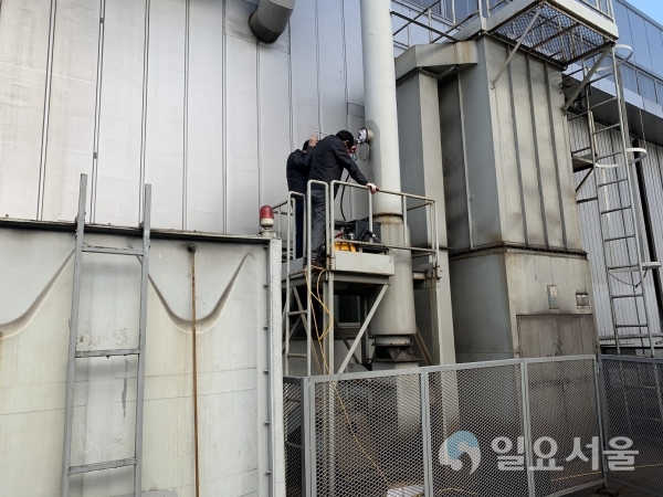 대기 측정검사TF팀이 공장 굴뚝 배출구에서 대기오염물질을 측정하고 있다.