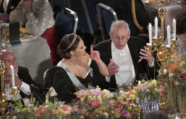 지난해 12월10일 스톡홀름 시청에서 열린 노벨상 시상식 연회에서 스웨덴 왕위 계승 서열 1위인 빅토리아(왼쪽) 왕세녀와 2019년 노벨 물리학상 수상자인 제임스 피블스(오른쪽)이 이야기를 나누는 모습. [뉴시스]
