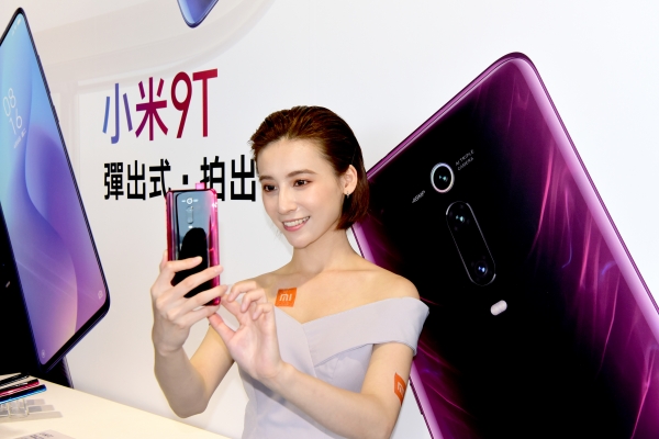 지난 6월 25일 대만에서 한 모델이 샤오미가 새로 출시한 스마트폰을 보여주고 있다. [뉴시스]