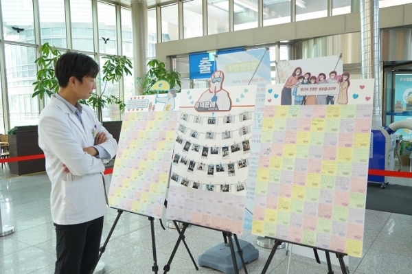동남권원자력의학원 로비에 전시된 신정고등학교 응원편지 게시물을 보고 있는 의료진.(사진=부경일보DB)