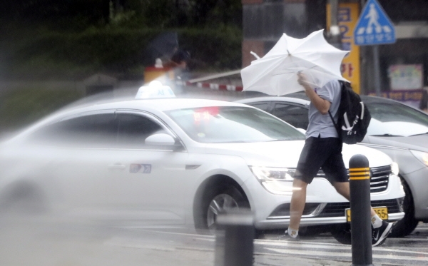 제9호 태풍 '마이삭'(MAYSAK)의 영향으로 강풍과 비가 내리고 있는 3일 서울 성북구에서 한 학생이 비바람을 피하며 발걸음을 재촉하고 있다. [뉴시스]