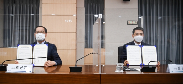양기관장이 협약서에 서명을 하고 협약서를 들어보이고 있다-(왼쪽) 전기안전공사 조성완 사장 (오른쪽)국토정보공사 김정렬 사장