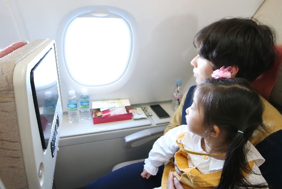아시아나항공의 A380 국토 순례 비행 상품을 이용는 승객이 자녀와 함께 창 밖을 내다보고 있다. [아시아나항공]