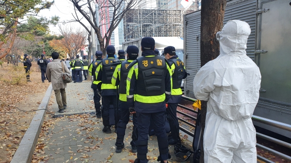 민주노총은 14일 오후 2시 서울 영등포구 여의도공원 앞에서 전국노동자대회·전국민중대회를 개최했다. 사진은 방호복을 입은 경찰들 [뉴시스]