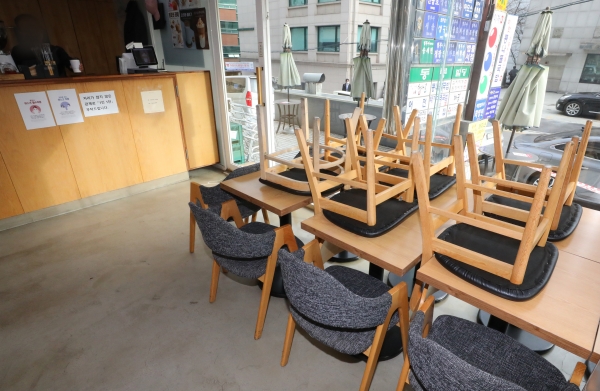 수도권 사회적 거리두기 2단계가 시행된 24일 오후 서울 서초구의 한 카페에 의자들이 테이블 위로 올라가 있다. 2단계 방역조치가 시행되면 카페는 포장과 배달만 허용되고 음식점은 21시 이후 포장, 배달만 가능하다. 2020.11.24. [뉴시스]