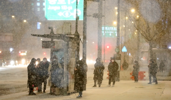 연일 한파가 이어지며 눈이 내리고 있는 6일 오후 서울 종로구 광화문네거리에서 시민들이 버스를 기다리고 있다. 2021.01.06. [뉴시스]