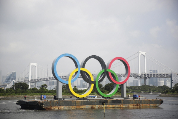 일본 도쿄 오다이바 해양공원 바지선에 설치됐던 2020 도쿄 올림픽&패럴림픽 오륜 조형물이 예인선에 이끌려 이동하고 있다. [뉴시스]