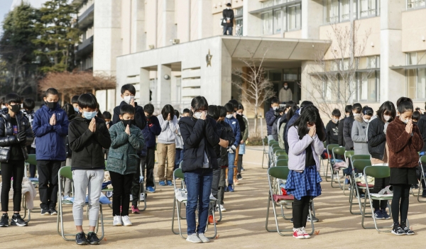 일본 서부 아시야 소재 초등학교에서 17일 열린 1995년 대지진 26주년 추모행사에 참석한 학생들이 코로나19 예방을 위해 마스크를 착용하고 거리를 둔 채 희생자에 묵념과 기도를 드리고 있다. 2021.01.17 [뉴시스]