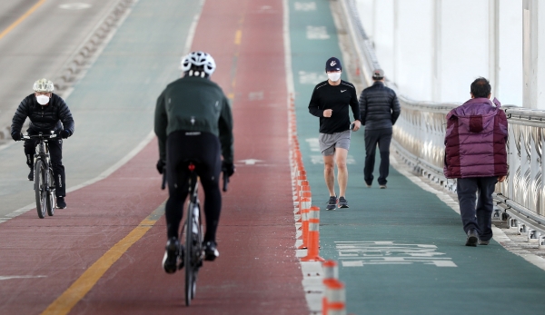 서울 낮 최고기온이 13도까지 오르며 포근한 날씨가 이어지는 25일 서울 서초구 잠수교에서 시민들이 자전거 및 러닝을 하고 있다. 2021.01.25. [뉴시스]